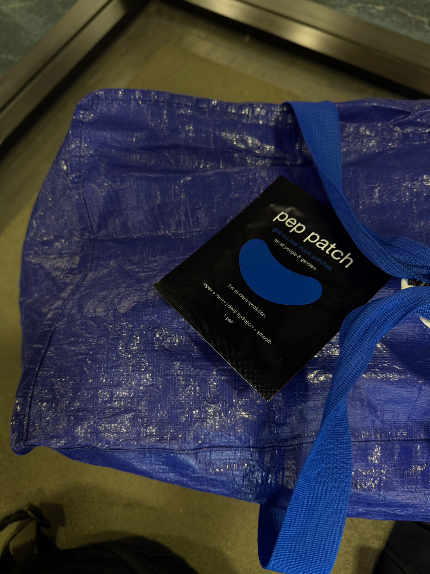 Pep Patch eye mask sachet packed with a cobalt blue travel tote